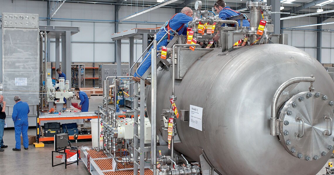 People in safety gear working in a factory