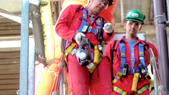 Portrait of two male engineers with full body harnesses.
