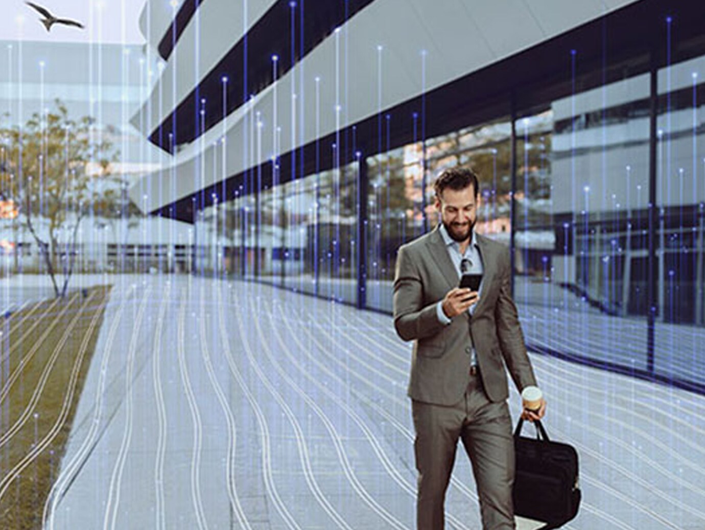 A businessman smiling at his phone while walking outside an office