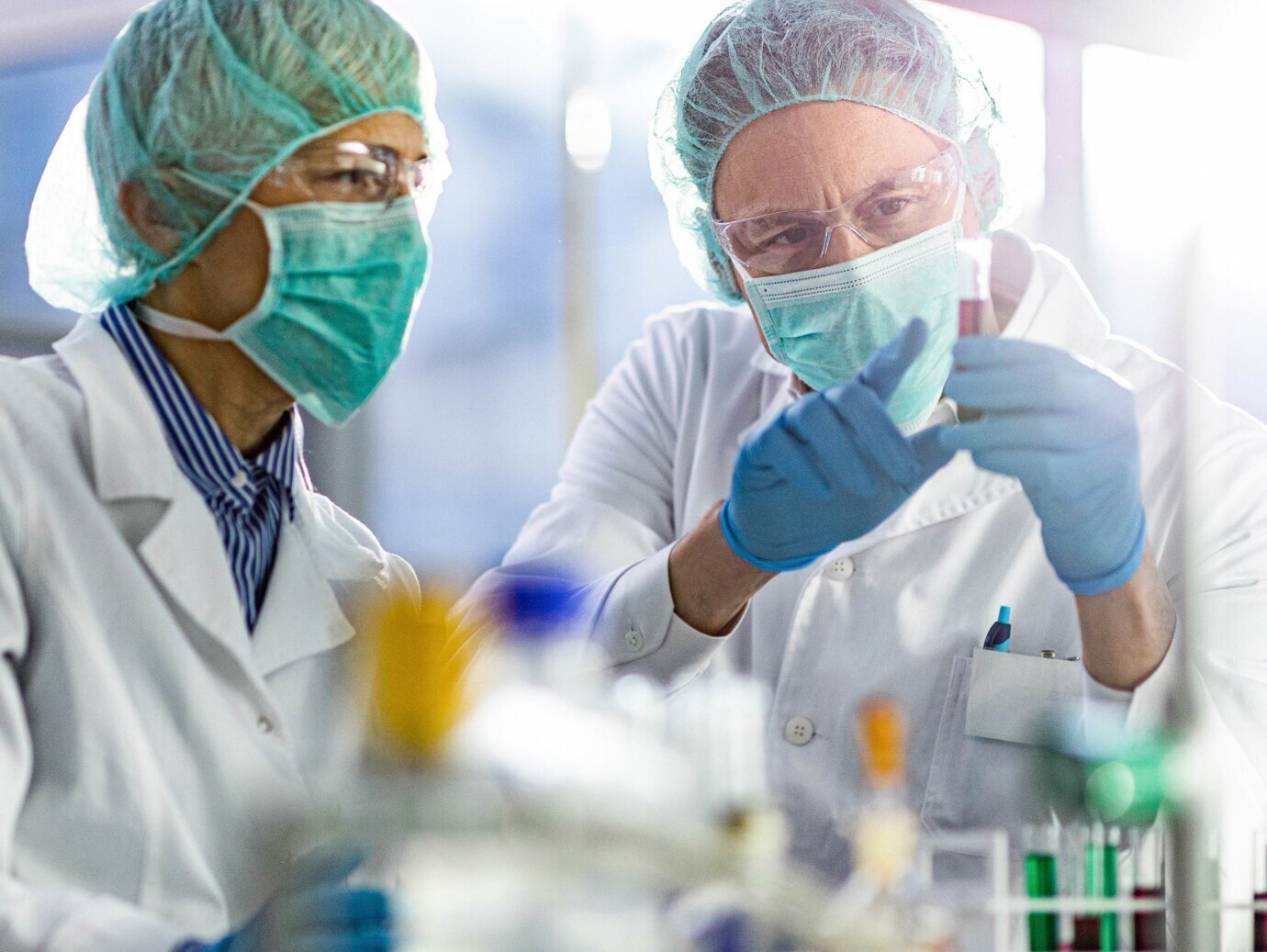Two scientists in a lab examining a substance in a test tube