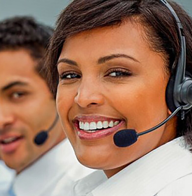 Call center employees seated in a row and smiling
