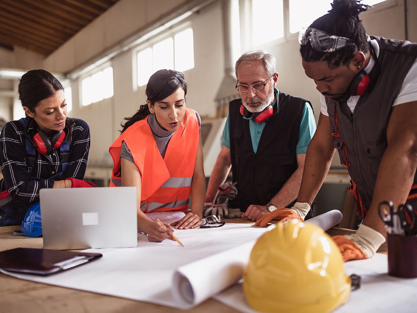 Diverse group of engineers going over a blueprint together