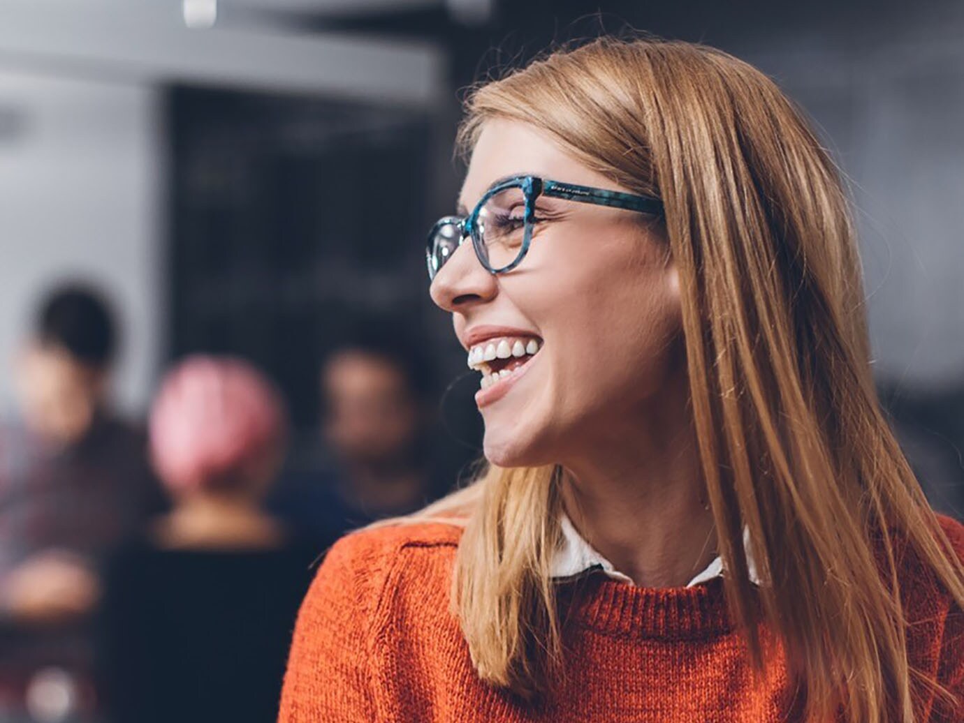 Woman wearing an orange sweater smiling
