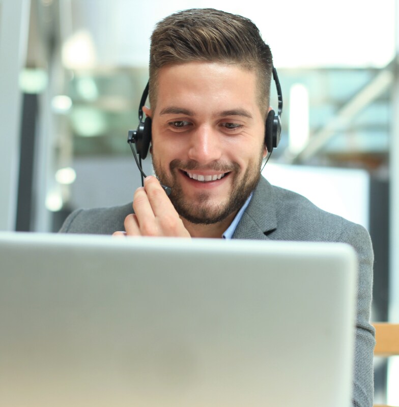 Man wearing_ headphones smiling at a laptop