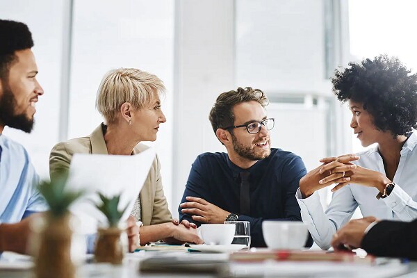 Group of office workers having a friendly conversation in a meeting room