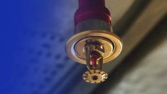 A water-based fire sprinkler attached to the ceiling