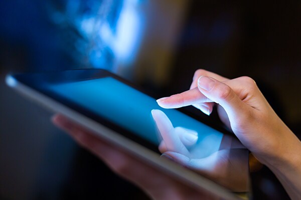 close-up on a person's hand tapping something on a tablet