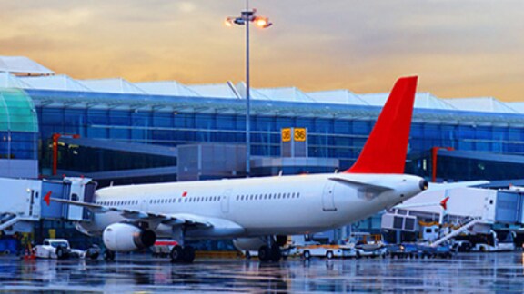 Airplane docked into a jet bridge at the airport apron