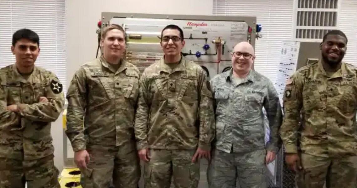 Army veterans at an HVAC facility, smiling