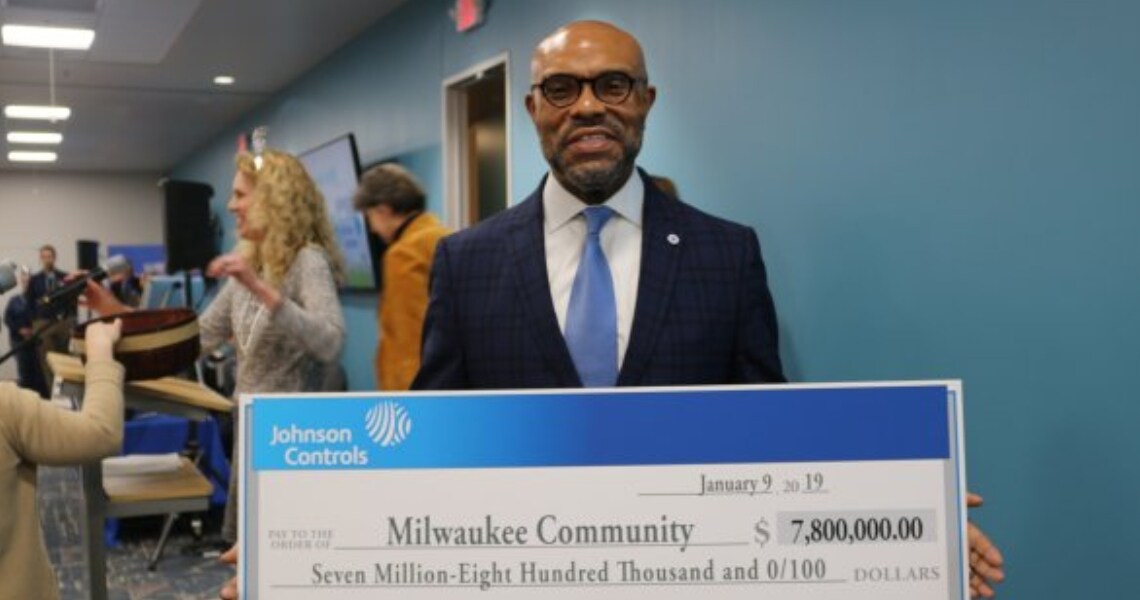 Grady Crosby, Johnson Controls vice president, Public Affairs, chief diversity officer and Foundation president, holding a check representing the funding Johnson Controls has committed to Milwaukee area non-profits for their operations and programming