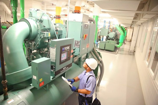 An HVAC technician examining a York chiller unit in a facility
