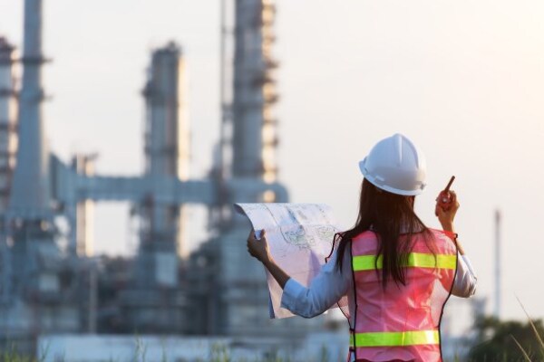 Woman in a safety helmet looking at a plan in a construction site