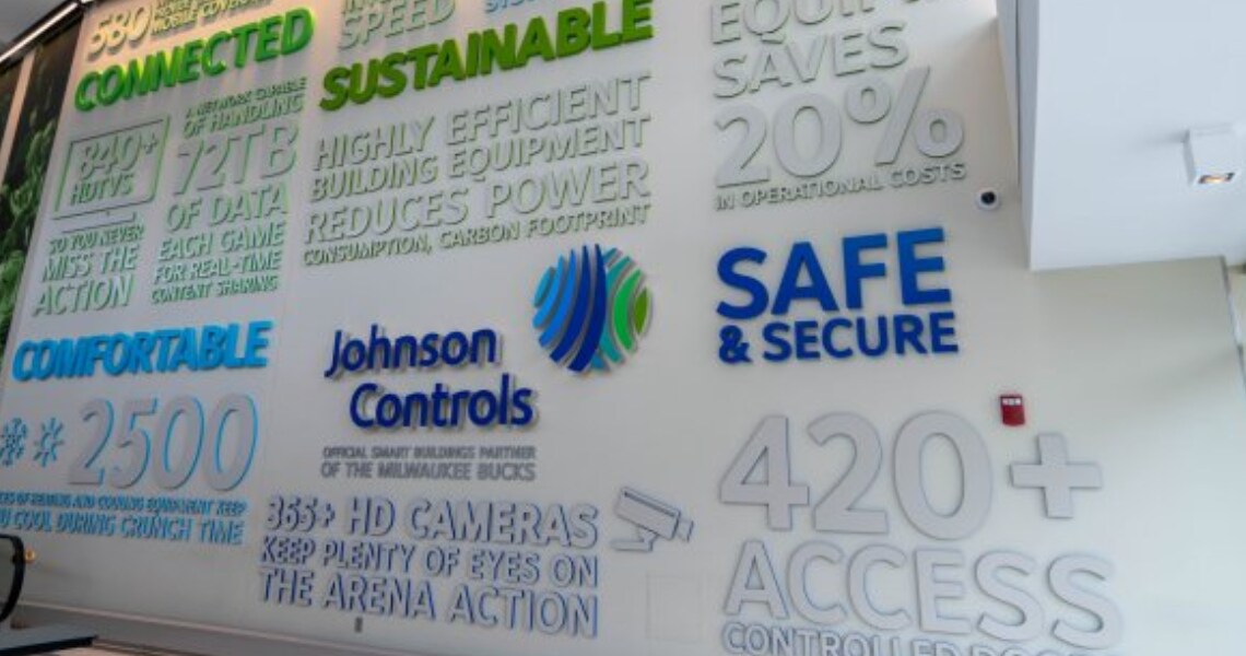 A wall with the Johnson Controls logo and milestones engraved at the Fiserv Forum