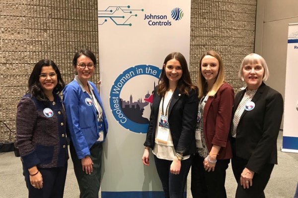 Women attendees posing near a banner at the Johnson Controls AHR Expo held in Atlanta