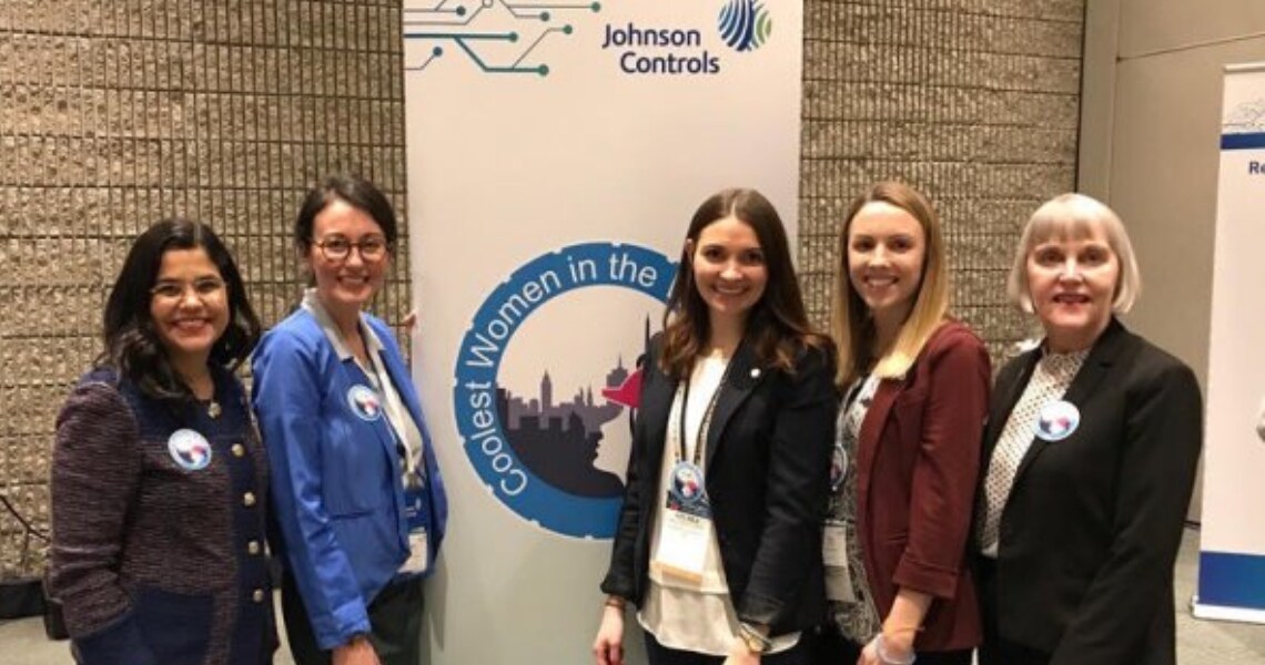 Women attendees posing near a banner at the Johnson Controls AHR Expo held in Atlanta