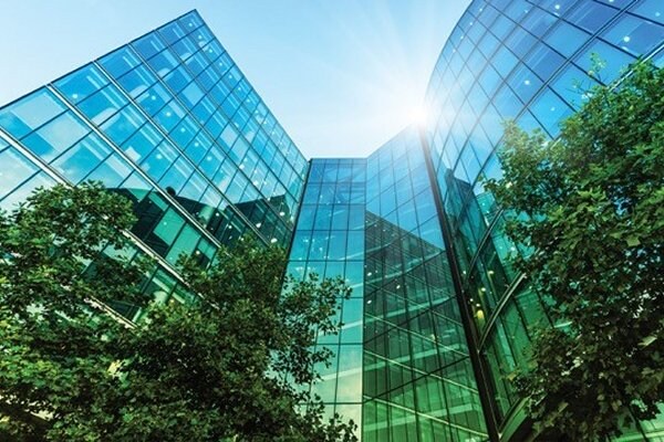 Frog's-eye view of glass buildings surrounded by trees