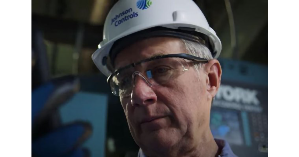 Close-up on a man's face wearing a safety helmet with a Johnson Controls logo on it