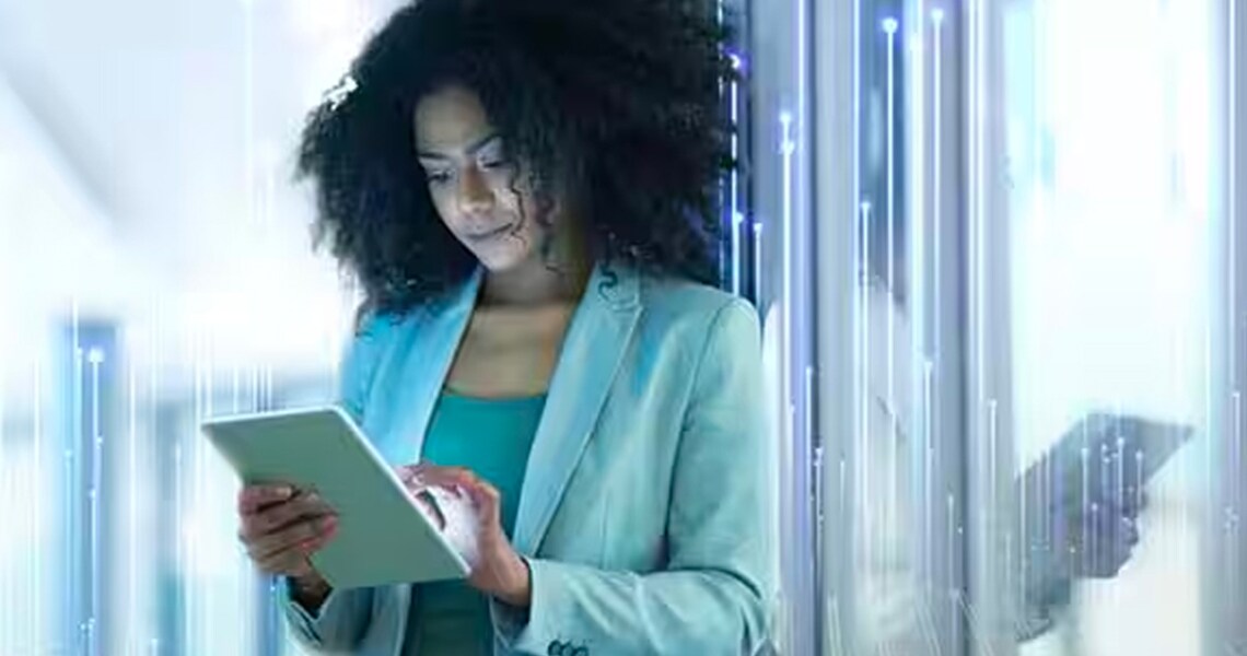 woman using a tablet by leaning on a glass door