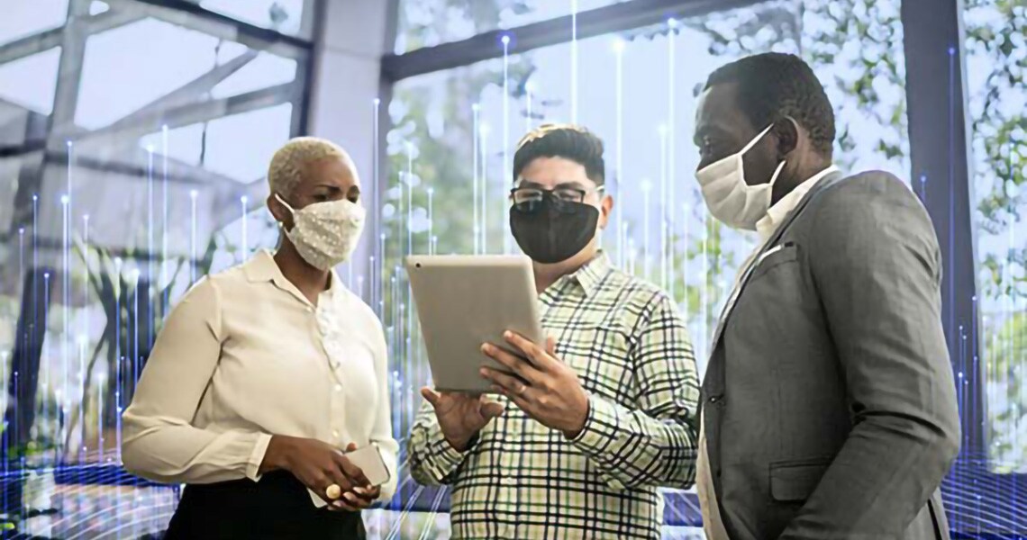 Masked colleagues convene over a tablet device