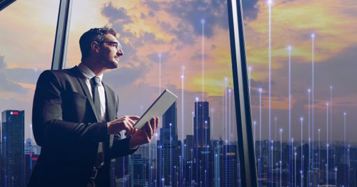 Man in formals working on a tablet and looking at a cityscape outside the window