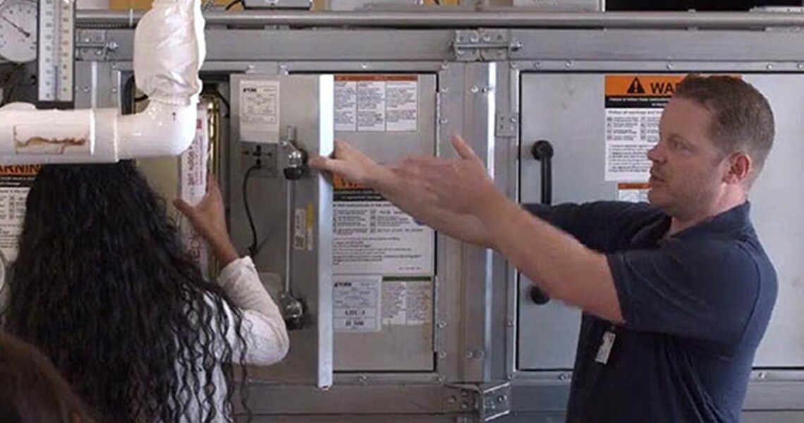 A mechanic and a young female student operating  HVAC equipment at the Commercial HVAC Pathways Vocational Lab