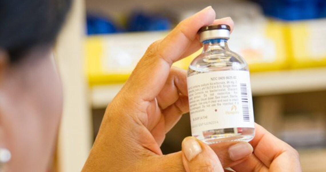 Close-up of a woman examining a bottle of medicine