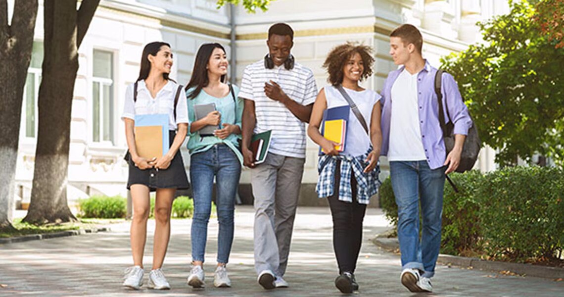 A group of college students chatting and walking around campus