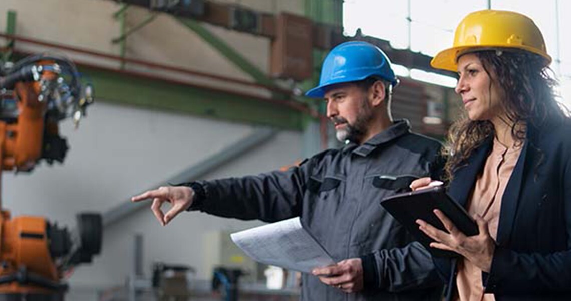 Two mechanics in a facility, with one of them pointing at something