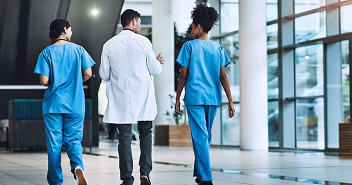 Three doctors walking and talking in a corridor
