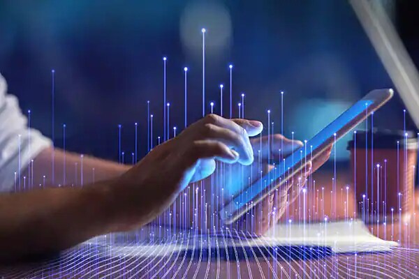 Close-up of a man scrolling on a screen tablet, overlaid with OpenBlue graphics 