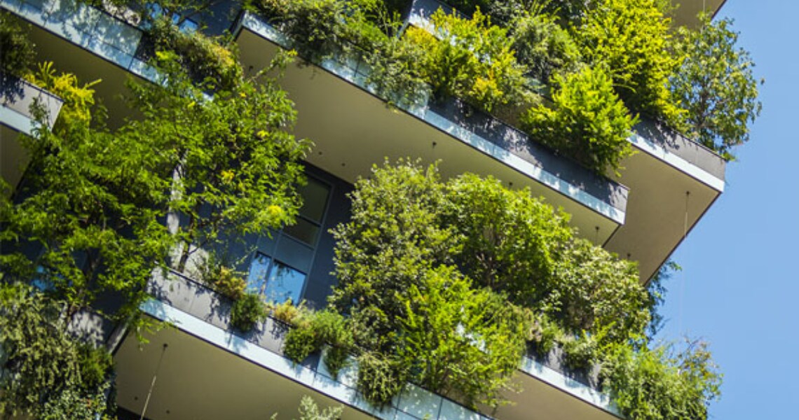 Upwards shot of a skyscraper with plants on each balcony