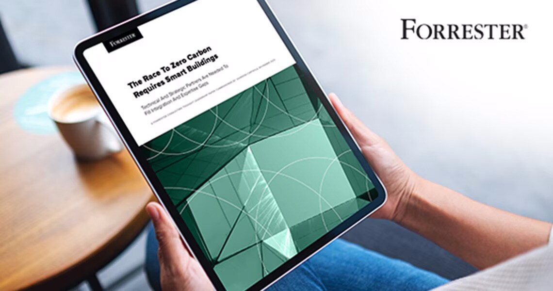 Person seated in an armchair, holding a tablet displaying a commissioned study by Forrester