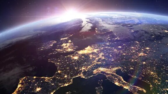 The sun rising over the earth as seen from space