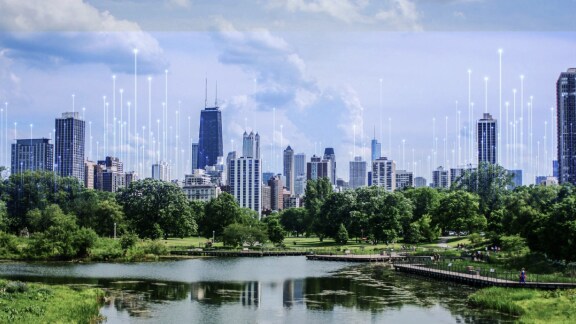 Waterfront view of a business area surrounded by greenery, overlaid with a graphic of transmission nodes