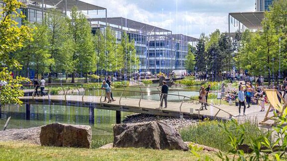 People walking along a bridge in a business park