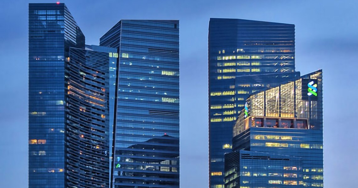 Two skyscrapers lit up at twilight