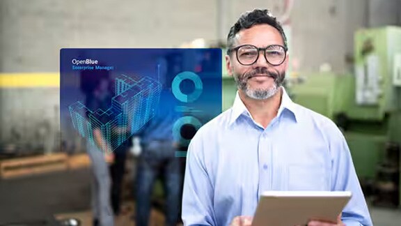 A man smiling and holding a tablet, with a blie OpenBlue poster overlaid in the foreground