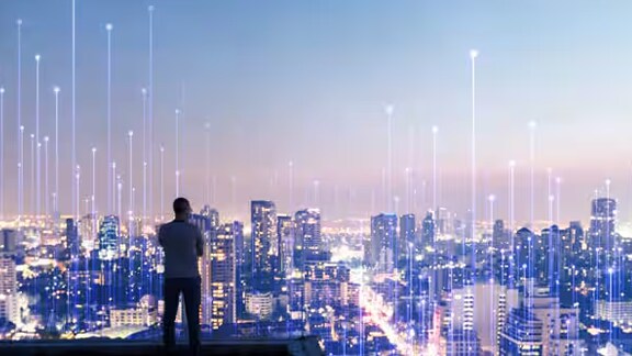 Man looking at the city from a rooftop, overlaid with a graphic of transmission nodes