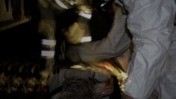 Maintenance workers kneeling in front of safety equipment