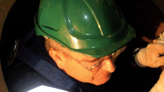 Maintenance worker climbing down a confined space