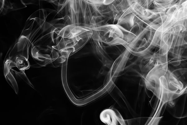 wisps of smoke against black background