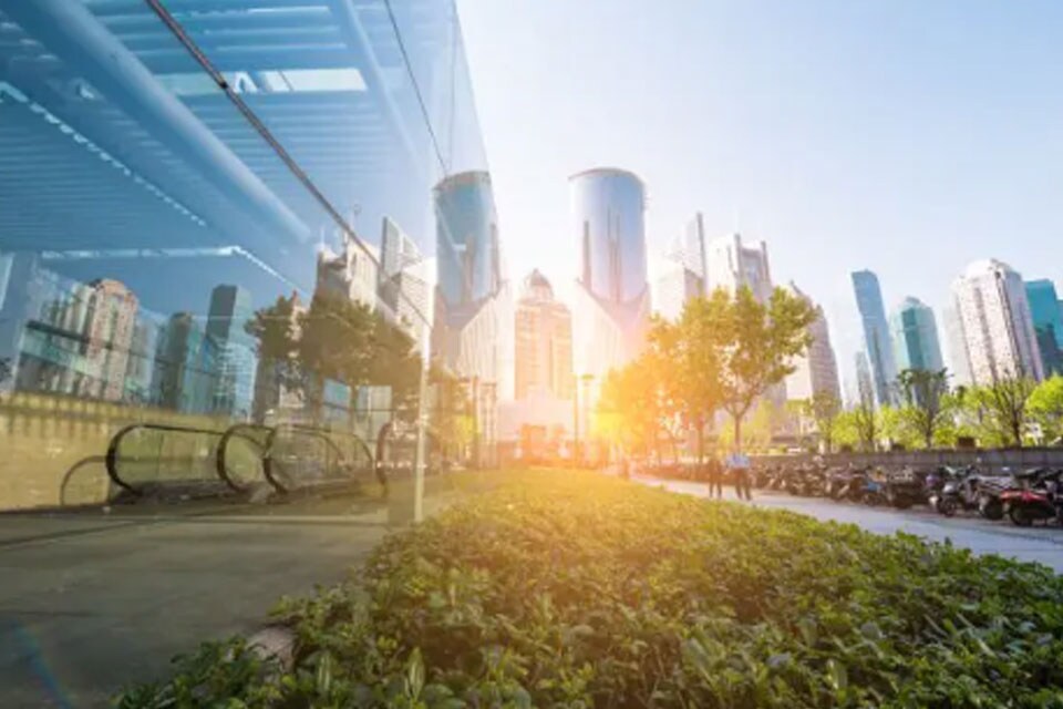Glass buildings with the sun shining between two buildings