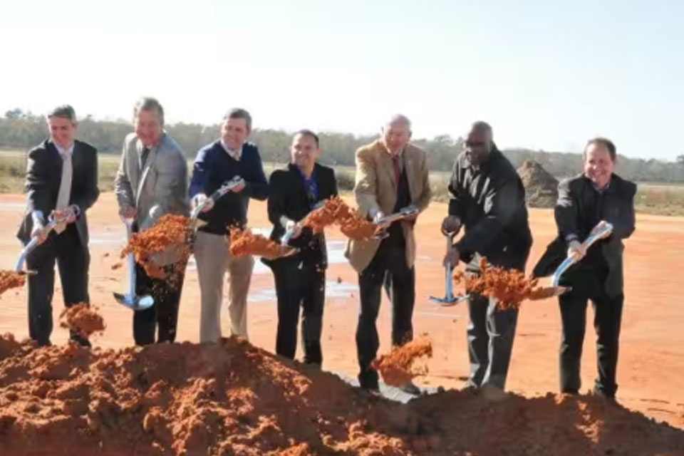 Johnson Controls representatives and partners digging up ground with shovels in a field