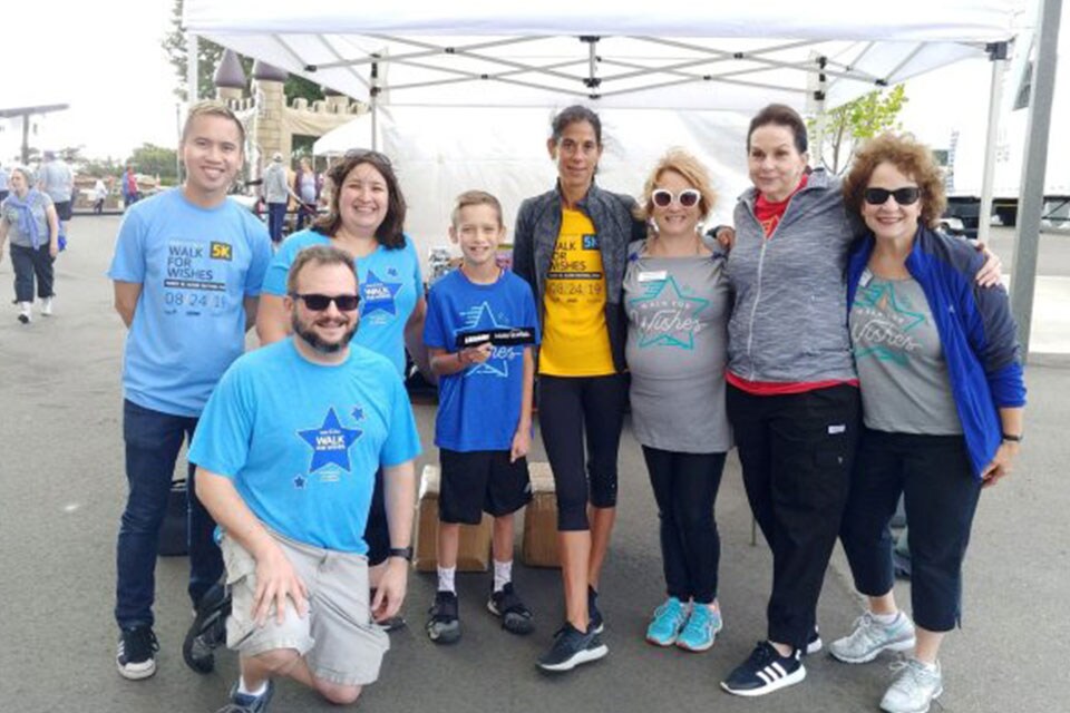 A group of people standing at the Make-A-Wish Walk For Wishes® fundraiser