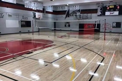 A badminton net set up in an indoor multipurpose gymnasium