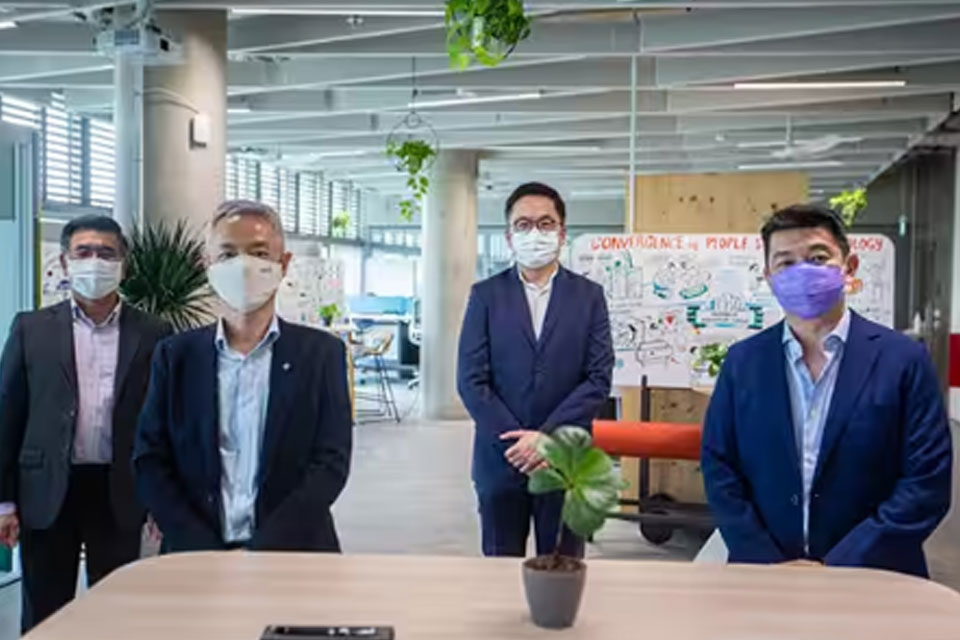 Businessmen in a conference room, wearing face masks and looking at the camera