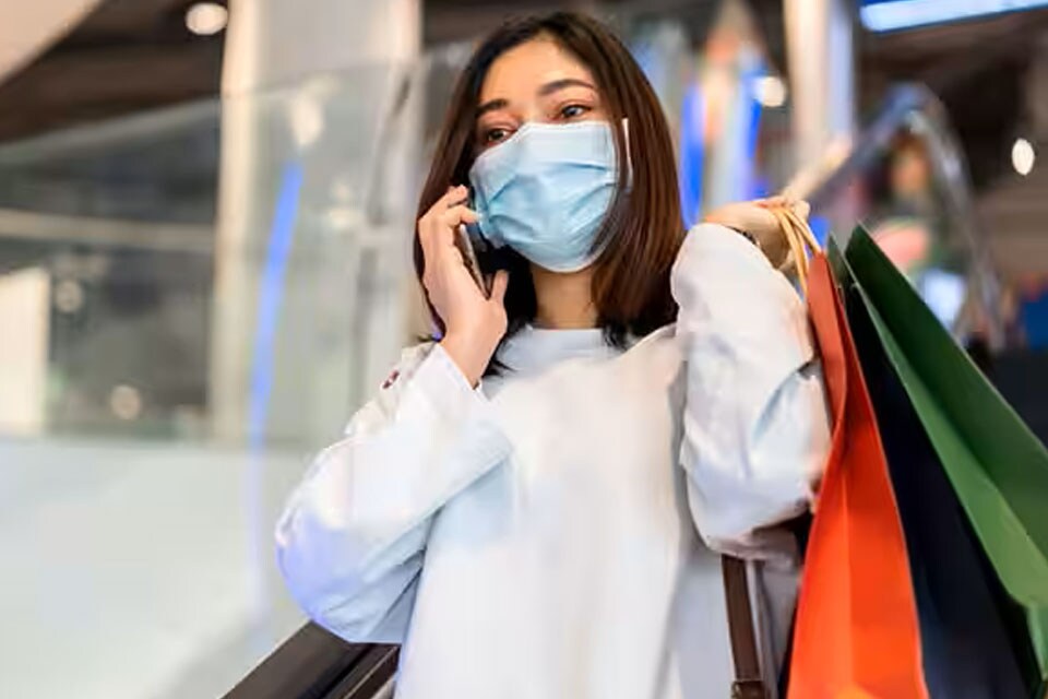 Woman on the phone, carrying shopping bags in the escalator