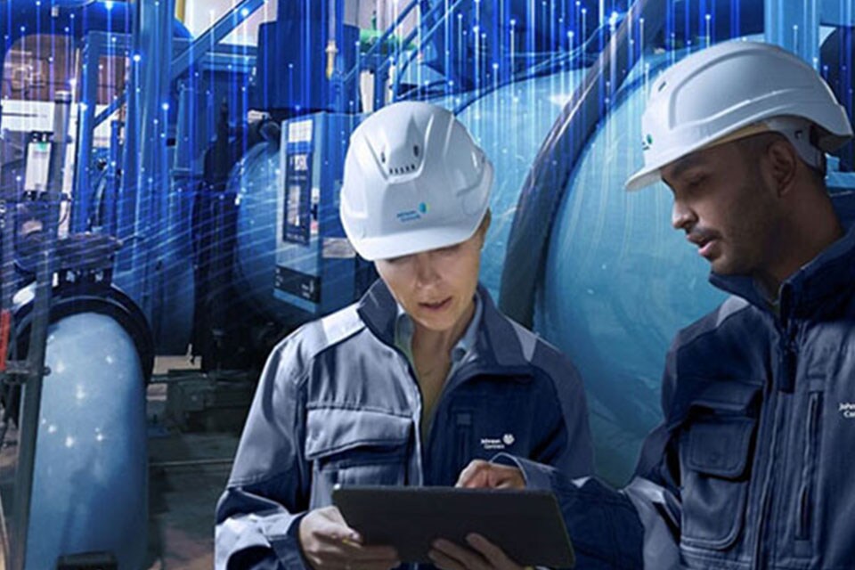 Two maintenance workers of Johnson Controls looking at a screen tablet