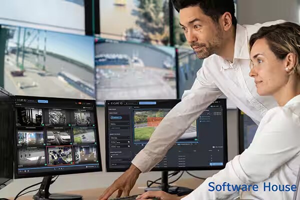 Two employees working on computers with "Software House" written at the bottom right side