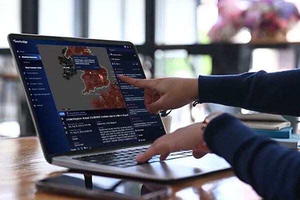 Finger pointing at a map open on a laptop screen